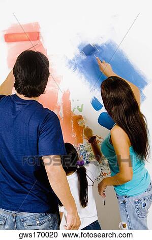 Rear view of a couple with their daughter painting a wall View Large Photo Image Stock Image - Rear view of a couple with their daughter painting a wall. Fotosearch