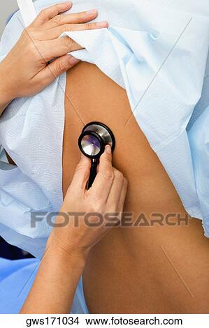 Close-up of a doctor's hand holding a stethoscope and examining a patient View Large Photo Image Picture - Close-up of a doctor's hand holding a stethoscope and examining a patient. Fotosearch