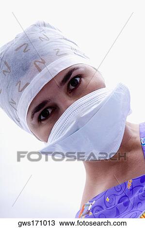 Stock Image - Close-up of a female nurse in a surgical mask and a surgical cap. Fotosearch