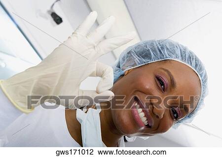 Close-up of a female surgeon smiling and making an OK sign View Large Photo Image Stock Image - Close-up of a female surgeon smiling and making an OK sign. Fotosearch