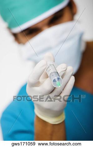 Close-up of a male surgeon holding a syringe View Large Photo Image Stock Photo - Close-up of a male surgeon holding a syringe. Fotosearch