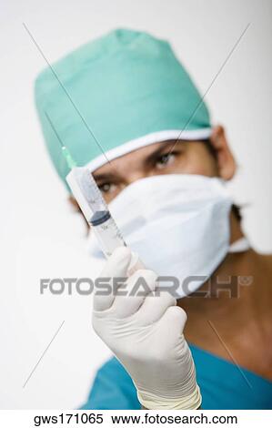 Close-up of a male surgeon holding a syringe View Large Photo Image Stock Photography - Close-up of a male surgeon holding a syringe. Fotosearch