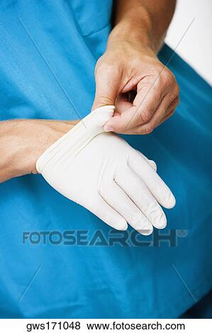 Close-up of a male surgeon's hand removing a surgical glove from his hand View Large Photo Image Stock Photo - Close-up of a male surgeon's hand removing a surgical glove from his hand. Fotosearch