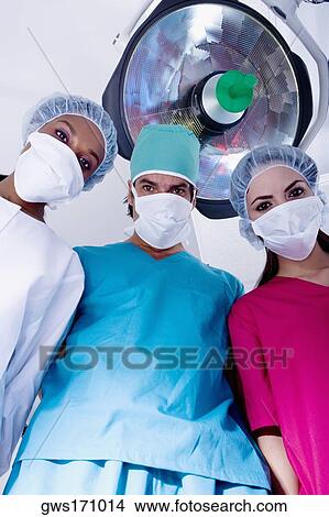 Low angle view of surgeons in an operating room View Large Photo Image Picture - Low angle view of surgeons in an operating room. Fotosearch