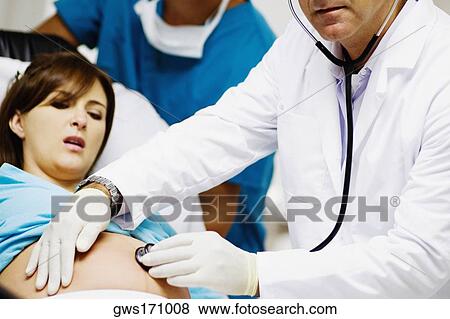 Male doctor examining a pregnant woman View Large Photo Image Stock Photo - Male doctor examining a pregnant woman. Fotosearch
