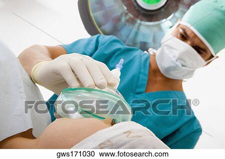 Male surgeon putting an oxygen mask on a female patient View Large Photo Image Stock Image - Male surgeon putting an oxygen mask on a female patient. Fotosearch