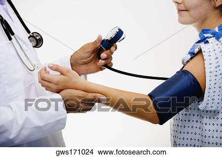 Picture - Mid section view of a male doctor measuring blood pressure of a female patient. Fotosearch