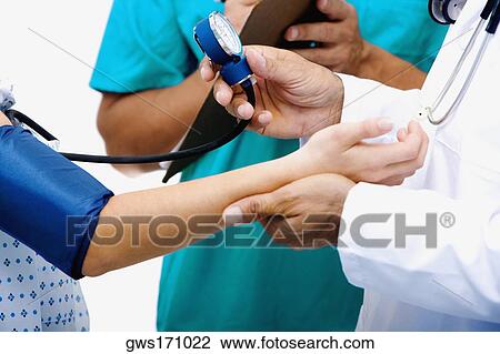 Mid section view of a male doctor measuring blood pressure of a female patient View Large Photo Image Stock Image - Mid section view of a male doctor measuring blood pressure of a female patient. Fotosearch