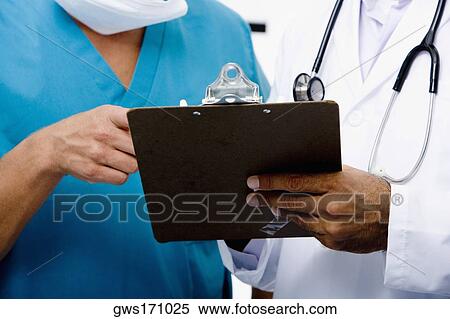 Mid section view of two doctors holding a clipboard View Large Photo Image Stock Photography - Mid section view of two doctors holding a clipboard. Fotosearch