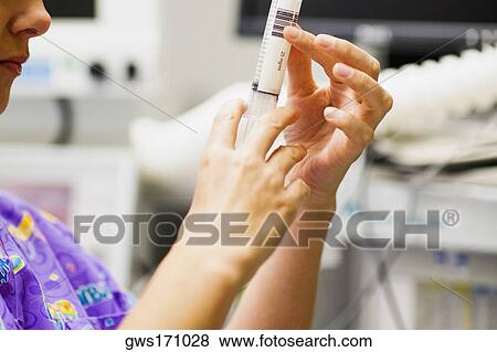 Side profile of a female doctor holding a syringe View Large Photo Image Stock Photo - Side profile of a female doctor holding a syringe. Fotosearch
