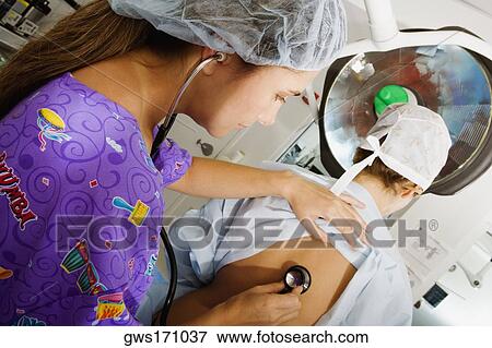 Side profile of a female doctor examining a female patient with a stethoscope View Large Photo Image Stock Photo - Side profile of a female doctor examining a female patient with a stethoscope. Fotosearch