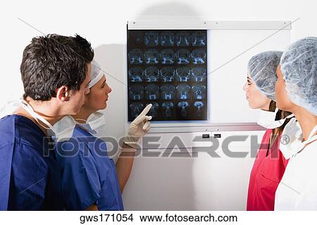 Side profile of a male surgeon and three female surgeons looking at a MRI scan View Large Photo Image Picture - Side profile of a male surgeon and three female surgeons looking at a MRI scan. Fotosearch