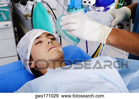 Surgeon's hand putting an oxygen mask on a female patient View Large Photo Image Stock Photo - Surgeon's hand putting an oxygen mask on a female patient. Fotosearch