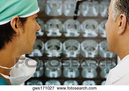 Two male doctors examining an X-Ray View Large Photo Image Stock Photo - Two male doctors examining an X-Ray. Fotosearch