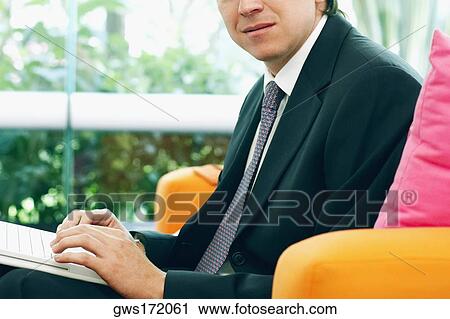Close-up of a businessman using a laptop View Large Photo Image Stock Image - Close-up of a businessman using a laptop. Fotosearch