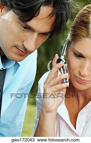 Close-up of a businesswoman and a businessman using a mobile phone View Large Photo Image Stock Image - Close-up of a businesswoman and a businessman using a mobile phone. Fotosearch