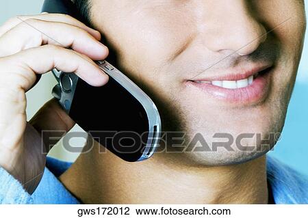 Stock Image - Close-up of a young man using a mobile phone. Fotosearch