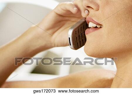 Close-up of a young woman talking on a mobile phone View Large Photo Image Stock Image - Close-up of a young woman talking on a mobile phone. Fotosearch