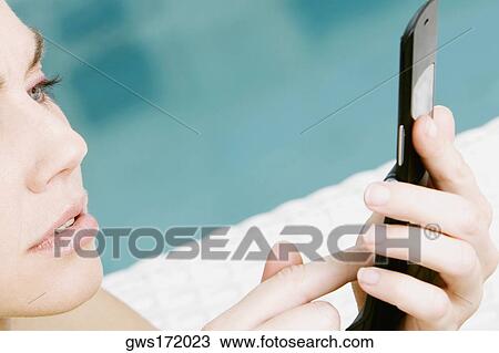 Close-up of a young woman using a mobile phone View Large Photo Image Stock Image - Close-up of a young woman using a mobile phone. Fotosearch