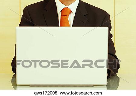 Mid section view of a businessman using a laptop View Large Photo Image Stock Photo - Mid section view of a businessman using a laptop. Fotosearch