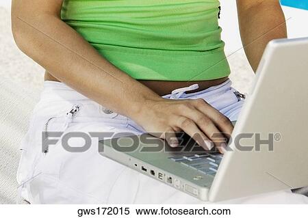 Stock Photography - Mid section view of a woman using a laptop. Fotosearch