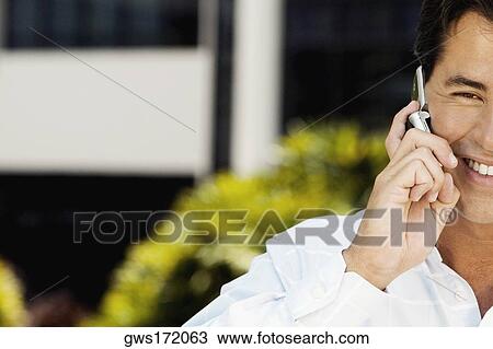 Stock Image - Portrait of a mid adult man using a mobile phone. Fotosearch