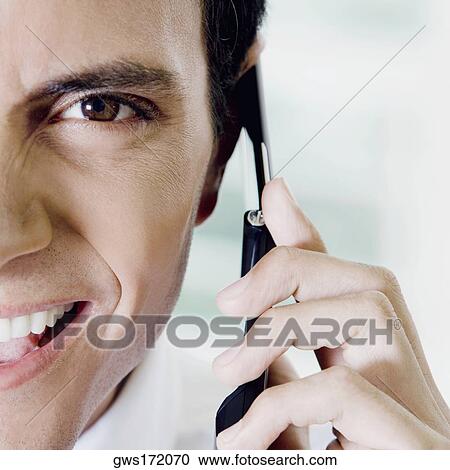 Portrait of a young man talking on a mobile phone View Large Photo Image Stock Image - Portrait of a young man talking on a mobile phone. Fotosearch