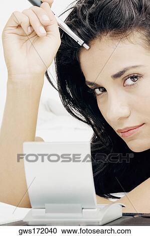Portrait of a young woman holding a pen View Large Photo Image Stock Image - Portrait of a young woman holding a pen. Fotosearch