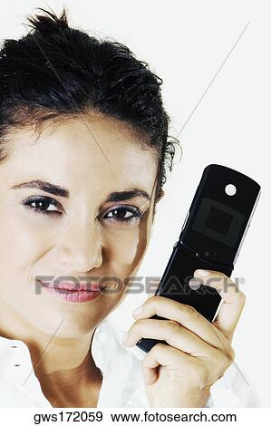 Portrait of a young woman holding a mobile phone View Large Photo Image Stock Photo - Portrait of a young woman holding a mobile phone. Fotosearch