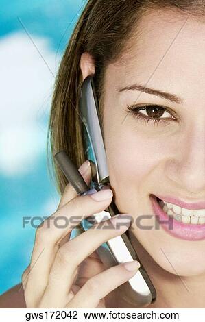 Portrait of a young woman using a mobile phone and smiling View Large Photo Image Stock Image - Portrait of a young woman using a mobile phone and smiling. Fotosearch