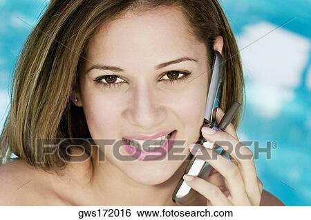 Portrait of a young woman using a mobile phone and smiling View Large Photo Image Stock Photograph - Portrait of a young woman using a mobile phone and smiling. Fotosearch