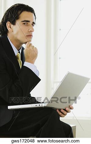 Side profile of a businessman with a laptop View Large Photo Image Stock Photo - Side profile of a businessman with a laptop. Fotosearch