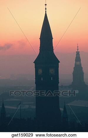 Stock Photo - Silhouette of a clock tower at dusk, City Hall, Copenhagen, Denmark. Fotosearch