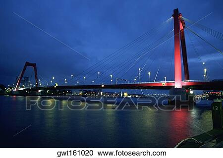 Stock Image - Suspension bridge across a river, Maas River, Rotterdam, Netherlands. Fotosearch