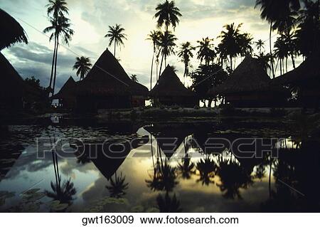 Reflection of huts and trees in water, Huahine Island, French Polynesia View Large Photo Image Stock Photo - Reflection of huts and trees in water, Huahine Island, French Polynesia. Fotosearch