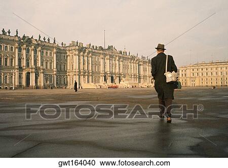 Stock Image - Rear view of a man walking in front of a palace, Winter Palace, Hermitage Museum, St. Petersburg, Russia. Fotosearch