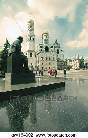 Stock Image - Tourists standing near a statue, Lenin Statue, Kremlin, Moscow, Russia. Fotosearch