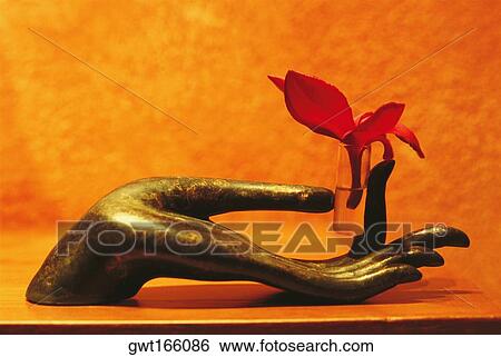 Stock Photograph - Close-up of a sculpture of a human hand holding massage oil, Koh Samui, Thailand. Fotosearch