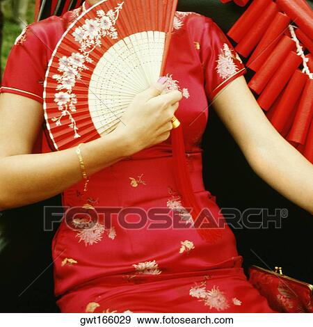 Stock Photo - Mid section view of a girl holding a folding fan, Singapore. Fotosearch