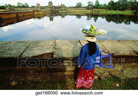 Rear view of a female vendor carrying lime fruit on her head, Angkor Wat, Angkor, Siem Reap, Cambodia View Large Photo Image Stock Image - Rear view of a female vendor carrying lime fruit on her head, Angkor Wat, Angkor, Siem Reap, Cambodia. Fotosearch