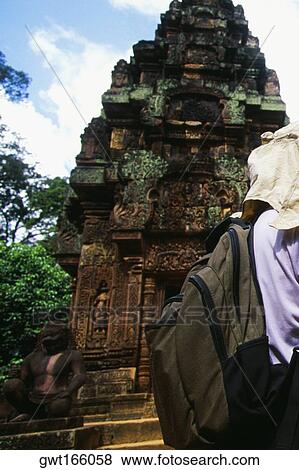 Rear view of a person standing in front of a temple, Banteay Srei, Angkor, Siem Reap, Cambodia View Large Photo Image Stock Photo - Rear view of a person standing in front of a temple, Banteay Srei, Angkor, Siem Reap, Cambodia. Fotosearch