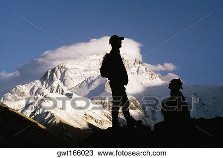 Silhouette of two men on a mountain with snow covered mountains in the background, Mt Everest, Tibet, China View Large Photo Image Stock Image - Silhouette of two men on a mountain with snow covered mountains in the background, Mt Everest, Tibet, China. Fotosearch