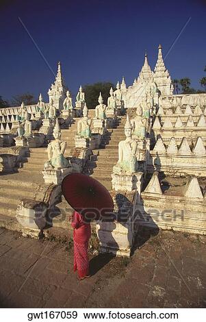 High angle view of a woman holding a parasol and standing in front of a pagoda, Mingun, Sagaing Divison, Myanmar View Large Photo Image Stock Photo - High angle view of a woman holding a parasol and standing in front of a pagoda, Mingun, Sagaing Divison, Myanmar. Fotosearch