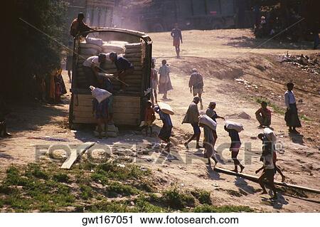 Stock Image - High angle view of manual workers loading a truck, Sagaing, Myanmar. Fotosearch