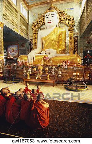 Rear view of monks praying in front of a statue of Buddha, Sagaing, Myanmar View Large Photo Image Stock Image - Rear view of monks praying in front of a statue of Buddha, Sagaing, Myanmar. Fotosearch