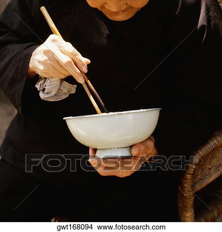 Close-up of a senior man eating with chopsticks, Xian, China View Large Photo Image Picture - Close-up of a senior man eating with chopsticks, Xian, China. Fotosearch
