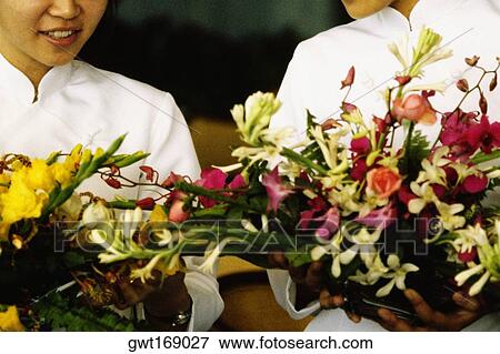 Close-up of two teenage girls holding flowers, Hong Kong, China View Large Photo Image Stock Photo - Close-up of two teenage girls holding flowers, Hong Kong, China. Fotosearch