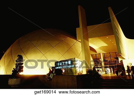 Picture - Low angle view of a museum lit up at night, Hong Kong, China. Fotosearch