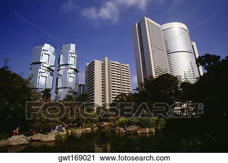 Stock Image - Low angle view of a park in front of buildings, Hong Kong, China. Fotosearch