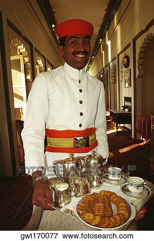 Portrait of a waiter holding a tray and smiling, Fateh Prakash Palace, Udaipur, Rajasthan, India View Large Photo Image Stock Photo - Portrait of a waiter holding a tray and smiling, Fateh Prakash Palace, Udaipur, Rajasthan, India. Fotosearch